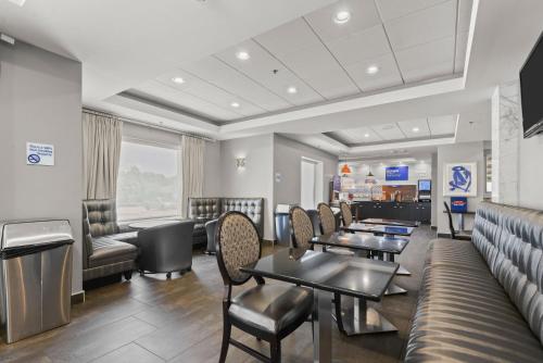 a waiting room with tables and chairs at Holiday Inn Express & Suites Gonzales by IHG in Gonzales