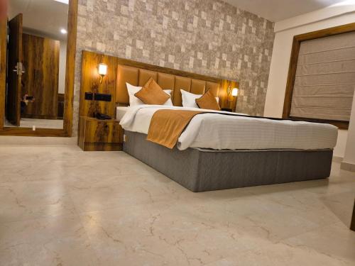 a large bedroom with a large bed and a bathroom at Hotel Orange in Bhubaneshwar