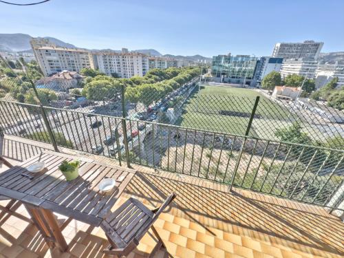 - un balcon avec une table, des chaises et un terrain de baseball dans l'établissement Vue Incroyable, Lumineux & Calme, à Marseille