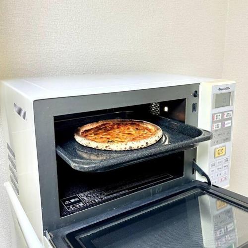 a pizza sitting on top of a microwave at サザンビーチ近く Seaside Villa 湘南茅ヶ崎 202 2DK 38m2 in Chigasaki