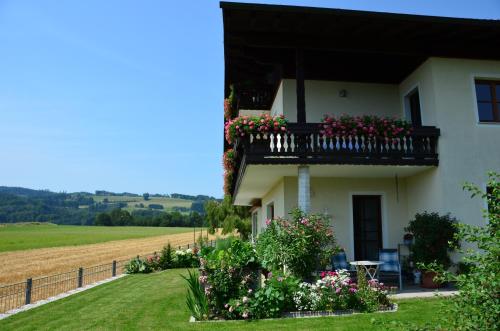 a white house with flowers on a balcony at Haus Gruber in Attersee am Attersee