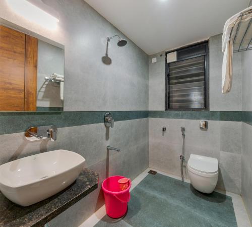 コールハープルにあるOrchid Avenueの白い洗面台とトイレのあるバスルーム