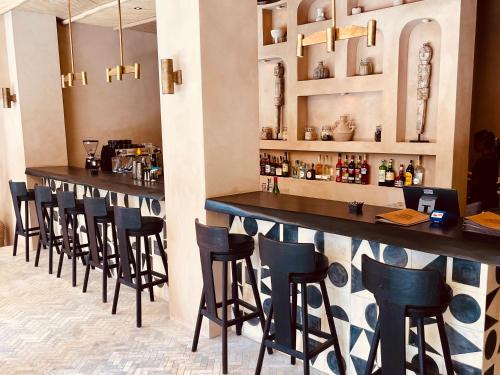 a bar with a row of stools in a restaurant at TheSoulHouseBali in Canggu
