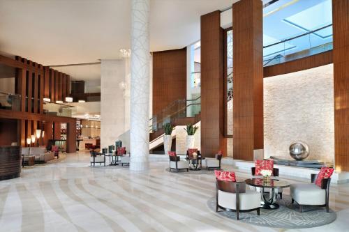 a lobby with tables and chairs in a building at Marriott Hotel Al Jaddaf, Dubai in Dubai