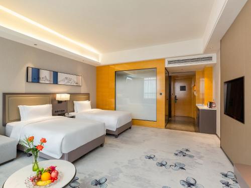 a hotel room with two beds and a television at Guangzhou Southern Airlines Pearl Airport Hotel- Free shuttle bus to airport in Guangzhou