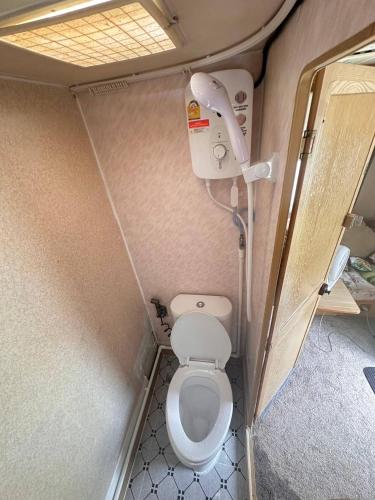 a small bathroom with a toilet in an rv at White House Beach Camping Caravans in Ban Thai Don (2)