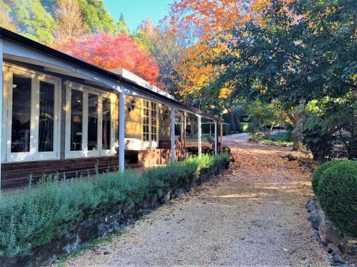 an old house with trees in the background at Huntington Lodge and Cottage in Mount Tomah
