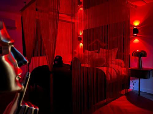 a red room with red curtains and red lights at Le fruit défendu 67 in Brumath