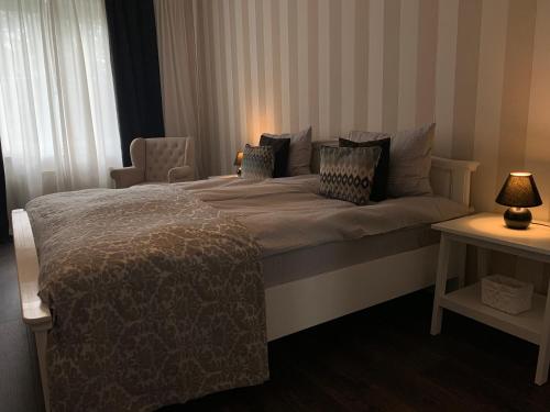 a bedroom with a bed and a chair and a window at AquaGate Jurmala in Jūrmala