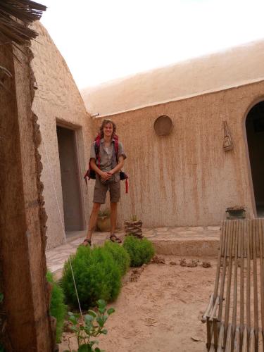 a man standing in a courtyard of a building at Dar alibaba in Douz