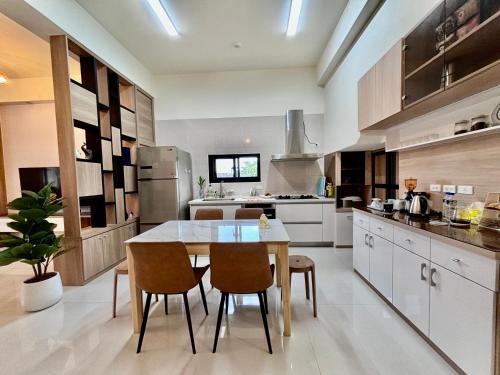 a kitchen with a table and chairs in it at Guangmei's home 台東縣民宿第2101號 in Chenggong