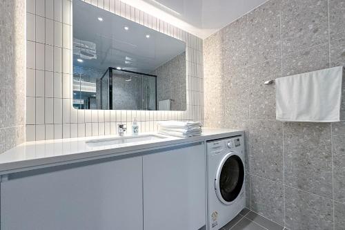a bathroom with a washing machine and a sink at The first ocean Songdo in Busan