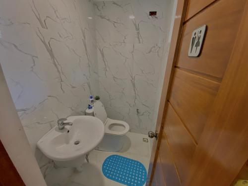 une salle de bain avec des toilettes blanches et un lavabo dans l'établissement Edimir Transient House, à Tagaytay