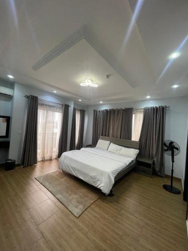 a bedroom with a white bed and some windows at two bedroom serviced apartment banana island - ikoyi JaeeLuxuryhomes in Lagos