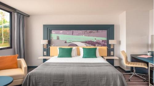 a bedroom with a large bed with green pillows at Holiday Inn Toulouse Airport by IHG in Blagnac