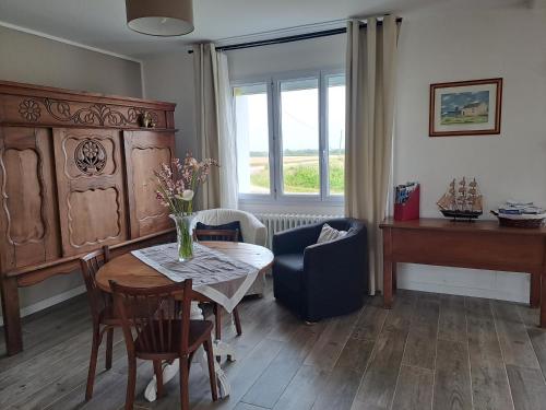 a living room with a table and a piano at Gîte breton au bord du GR34 in Landunvez