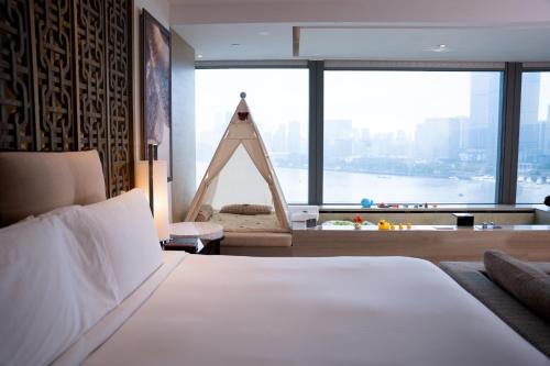 Una cama o camas en una habitación de Banyantree Shanghai On the Bund - Tales rooftop bar boasts a jaw-dropping panoramic vista