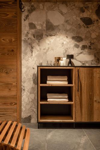 a wooden cabinet in a room with a stone wall at Owce Dwie in Zakopane