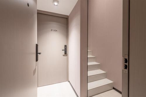 a staircase in a room with a glass door at ONESS Executive Hotel Guangzhou Huangpu-Free Shuttle Bus from 15th October to 5th November in Guangzhou