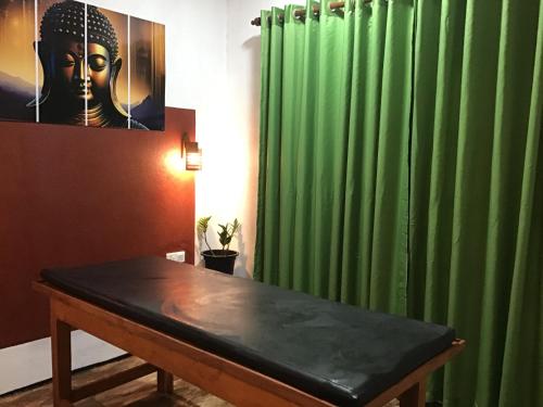 a room with a table and a green curtain at SanjeeHome & Lanka Ayurveda, Bentota in Bentota
