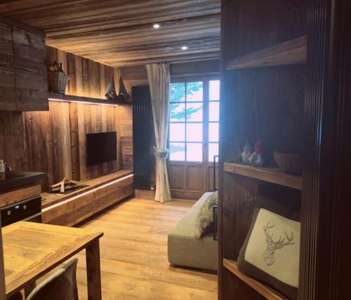 a living room with wooden walls and a large window at Monolocale walser in Formazza