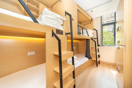 a room with bunk beds in a tiny house at 际庭青年旅舍-马当路地铁站店 in Shanghai