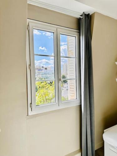 une fenêtre avec vue sur la ville dans l'établissement Appartement vue tour Eiffel ligne 14 à côté de Paris, à Gentilly