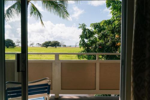 a window with a view of a field outside at Plantation Hale Suites in Kapaa