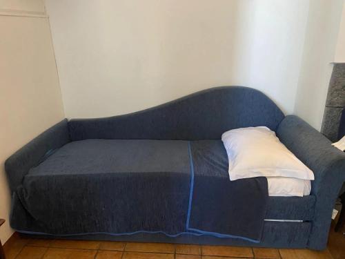 a blue couch with a pillow on top of it at Charming house with sea view in Capo Mulini in Capo Mulini