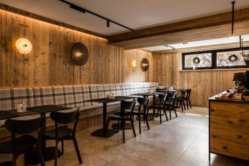 a restaurant with wooden walls and tables and chairs at Owce Dwie in Zakopane