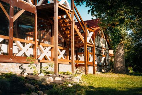 a wooden building with a fence in the grass at Ranczo Brusno in Połczyn-Zdrój