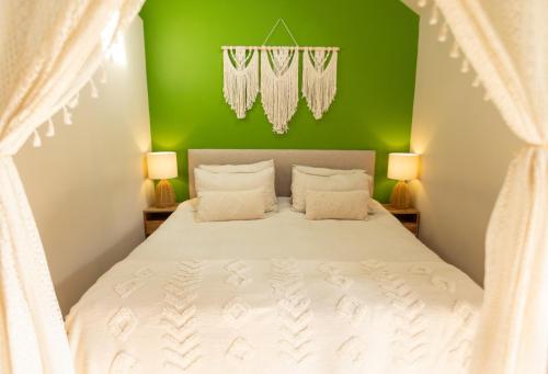 una camera con un letto bianco e una parete verde di Romantic Snowdonia Cottage with Hot tub, sea & mountain views a Tywyn