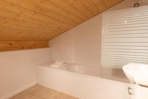 une salle de bain blanche avec une baignoire et un lavabo dans l'établissement Chalet Plan Fert, aux Gets