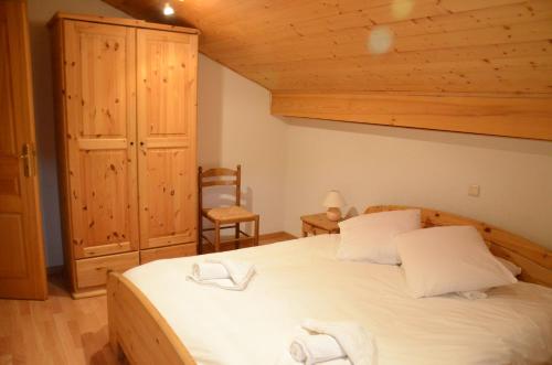 une chambre avec un grand lit et une chaise dans l'établissement Chalet Plan Fert, aux Gets