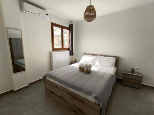 a bedroom with a bed with white sheets and white pillows at Coralia's House in Nea Moudania