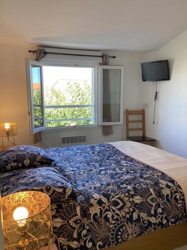 une chambre avec un lit avec une couette bleue et une fenêtre dans l'établissement La BénéCIOLA, vue Mer, Box Fibre SFR, High Speed Internet, à Cervione