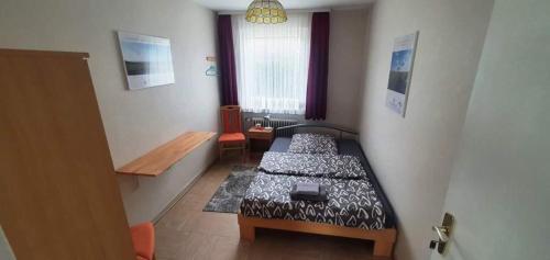 a small bedroom with a bed and a window at Apartment Terrasse in Gau-Weinheim