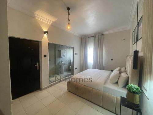 a bedroom with a large bed and a bathroom at Stylish and Comfy 2 BR Apartment - Perfect for Families in Lagos