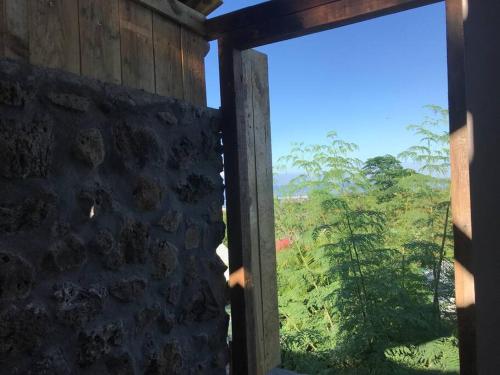 an open window with a view of a forest at Caze La Pointe Magnifique vue sur le Lagon in Saint-Paul