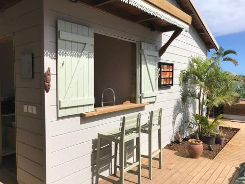 a patio with a table and chairs outside of a house at Caze La Pointe Magnifique vue sur le Lagon in Saint-Paul