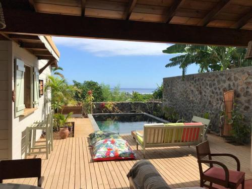 a patio with a bench and a swimming pool at Caze La Pointe Magnifique vue sur le Lagon in Saint-Paul