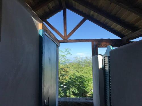 a window in a room with a view of a tree at Caze La Pointe Magnifique vue sur le Lagon in Saint-Paul