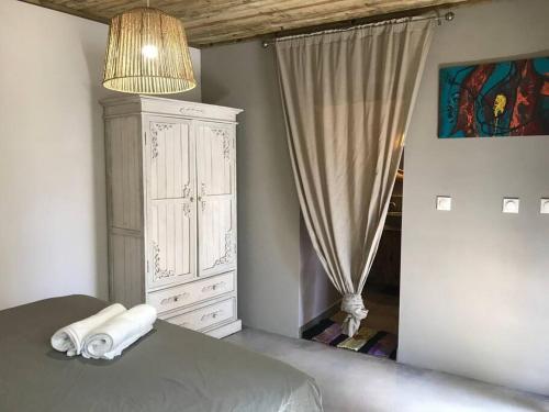 a bedroom with a bed and a dresser and a window at Caze La Pointe Magnifique vue sur le Lagon in Saint-Paul