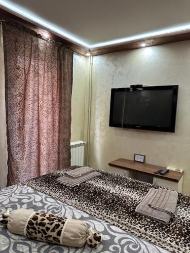 a room with a bed with a television on the wall at Imperija in Kragujevac
