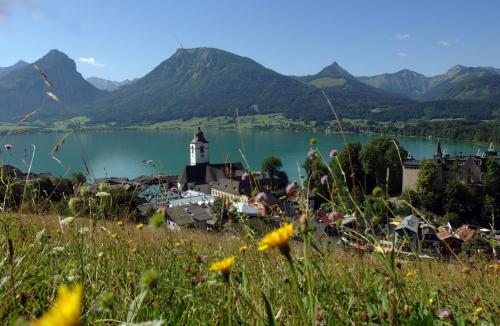 a small town with a lighthouse in the middle of a lake at Romantik Hotel Im Weissen Rössl am Wolfgangsee in St. Wolfgang