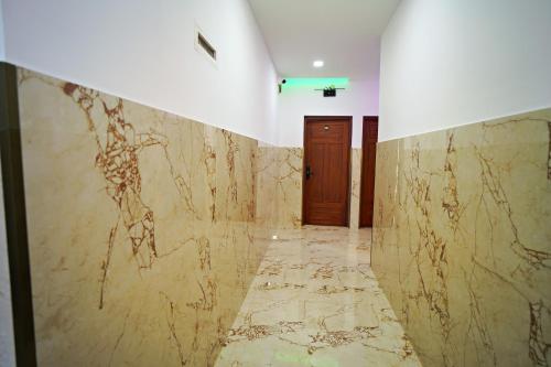 a hallway with a marble wall and a door at GH Grand Park in Angamali