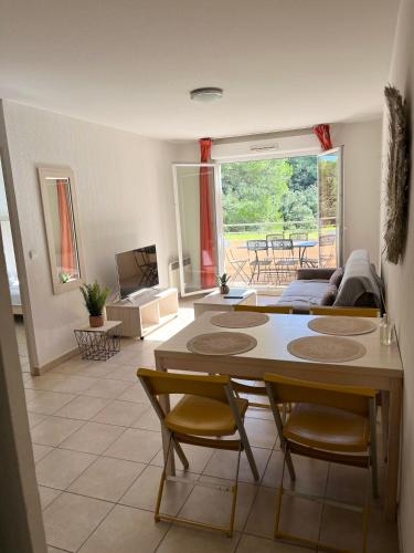 un salon avec une table et des chaises dans l'établissement Fabuleux appartement avec piscine, à Roquebrune-sur Argens