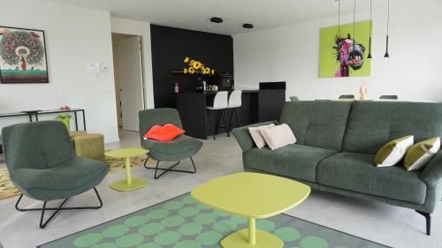 a living room with a couch and chairs and a table at Faro Greenpark APP 01, Cadzand-Bad in Cadzand