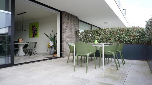 a table and chairs sitting on a patio at Faro Greenpark APP 01, Cadzand-Bad in Cadzand