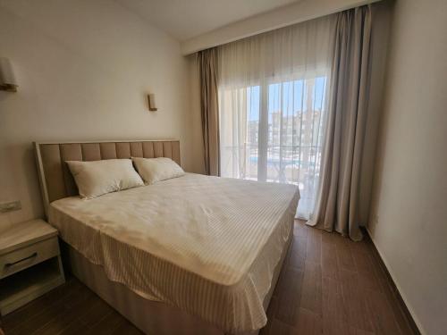 une chambre avec un lit et une grande fenêtre dans l'établissement Fully equipped studio Sahl Hasheesh, à Hurghada